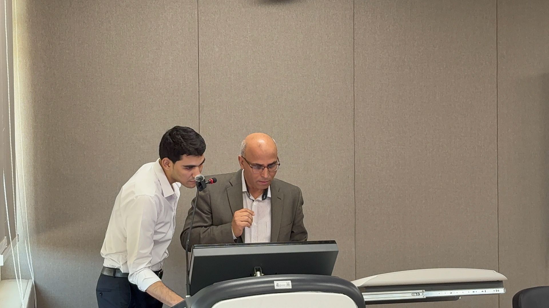 AOU Research Day 2026: Moaz helping a professor to open slides