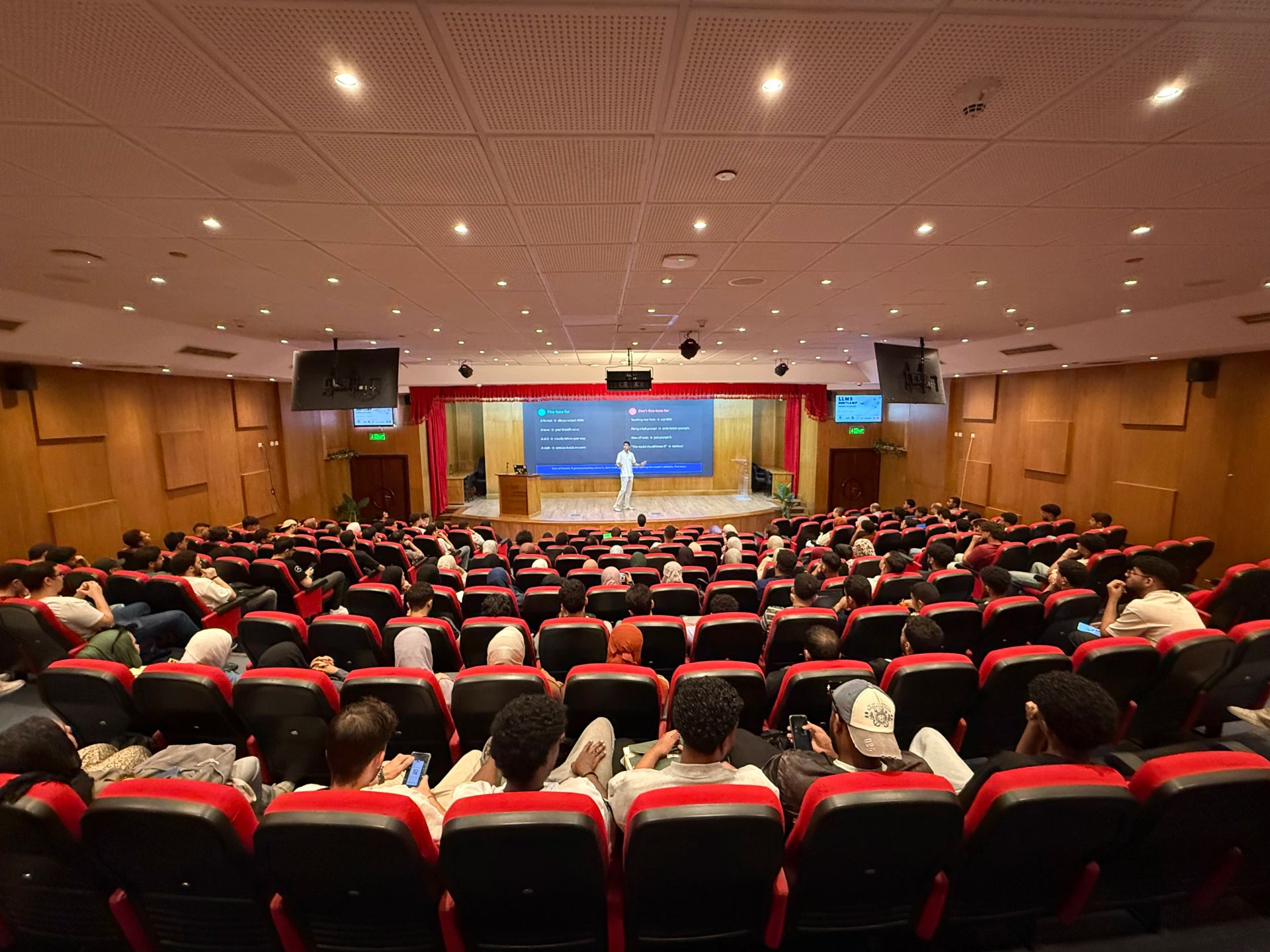 LLM Engineering Bootcamp: From Foundations to Deployment: A view of the theater filled with an audience from back