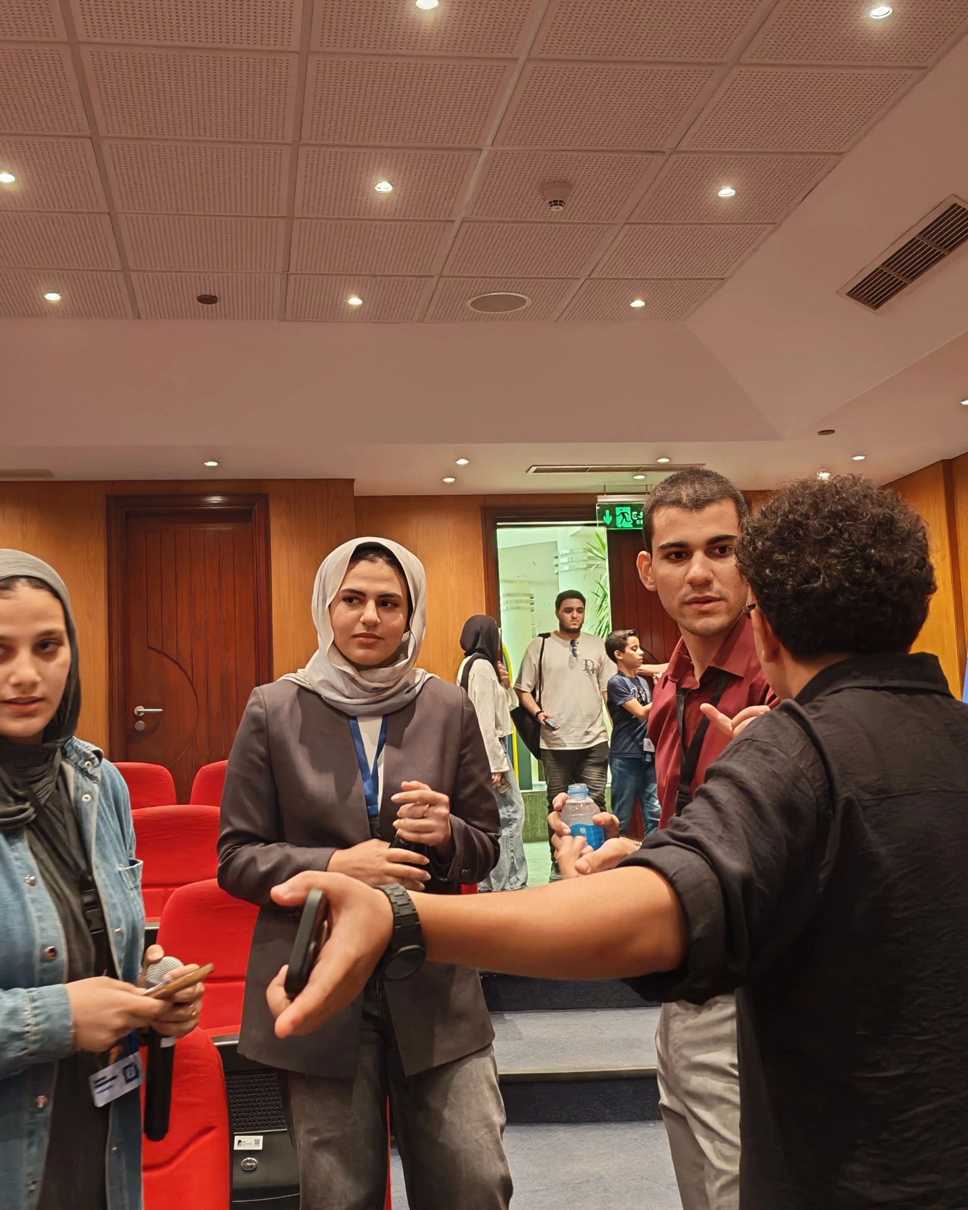 LLM Engineering Bootcamp: From Foundations to Deployment: Moaz with 3 team members talking on organization